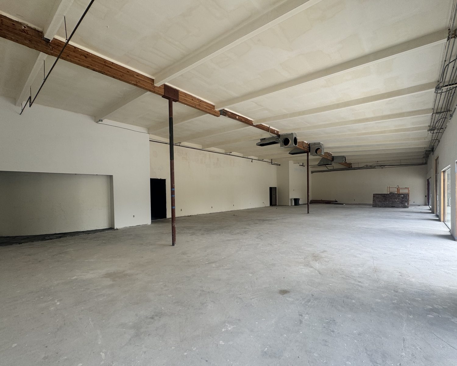 Interior of Suite A-14 showing the open-span floor plate and exposed timber ceiling