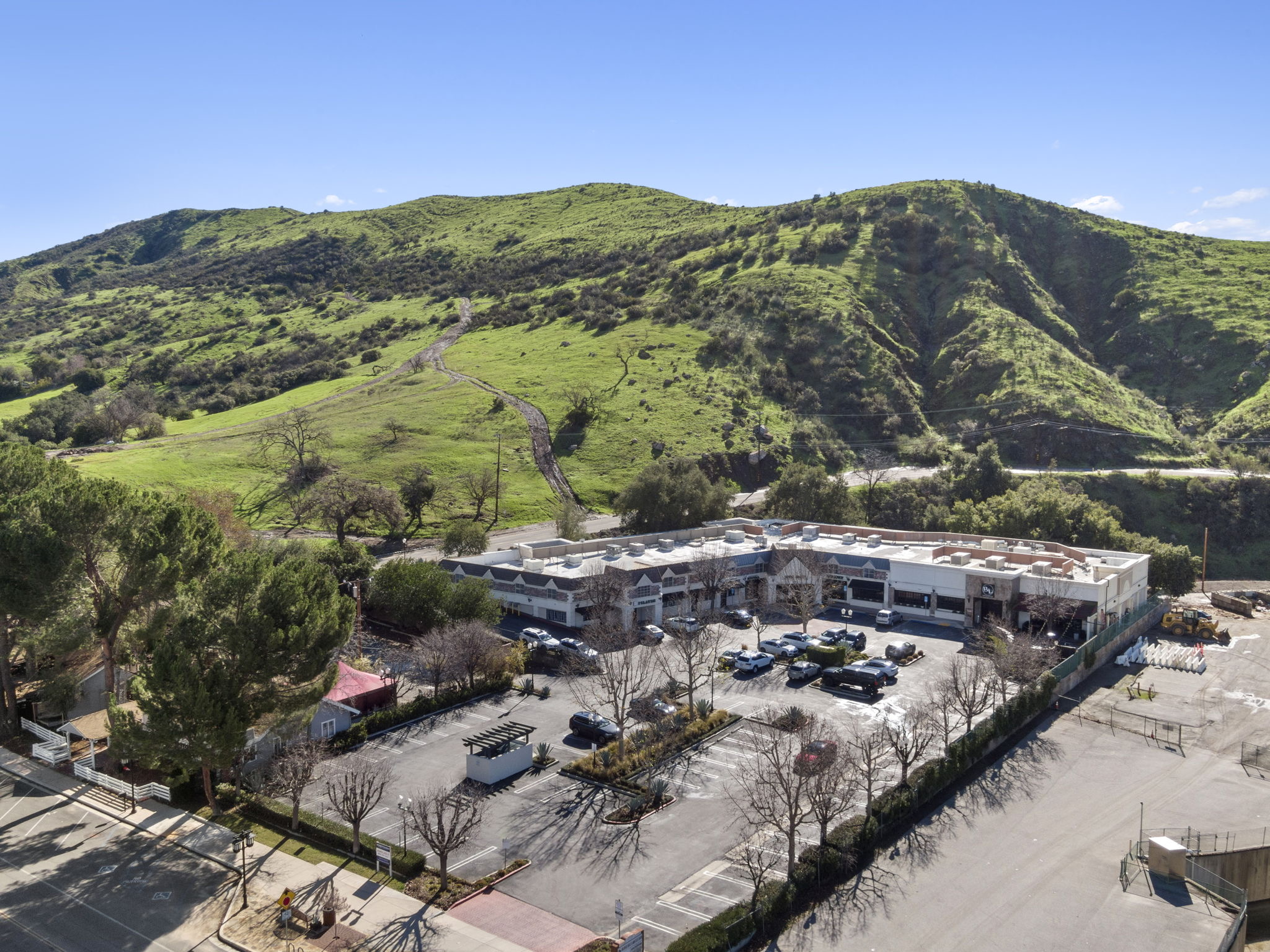 Aerial view of Agoura Village Center with the green hills of the Santa Monica Mountains rising behind it